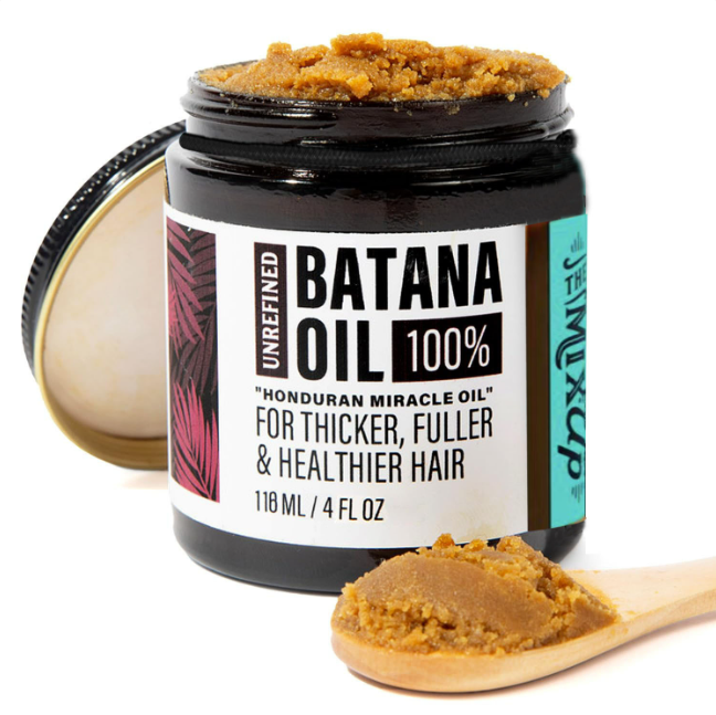 Jar of Glow Restore hair mask next to a wooden scoop and hair strands
