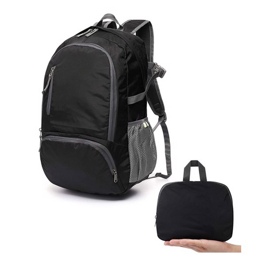 Foldable 35L ultralight backpack folded flat beside travel gear